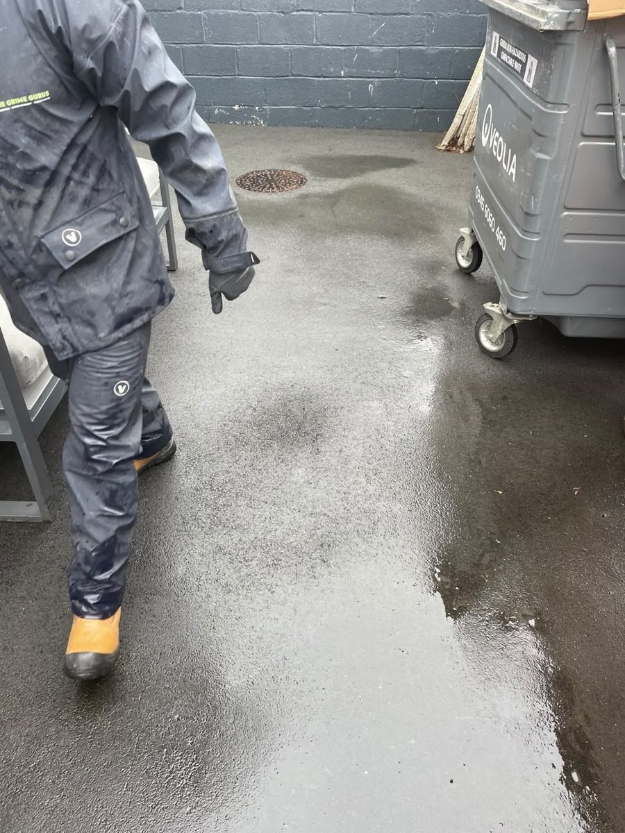 A wide path part-way through being jet washed, half clean and half green