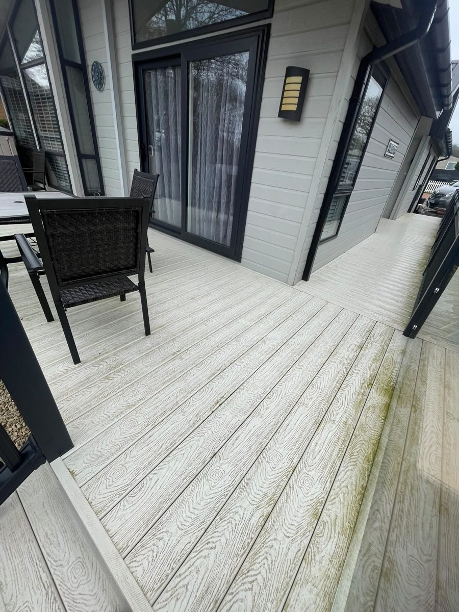 Composite decking after cleaning, with a chair and patio doors