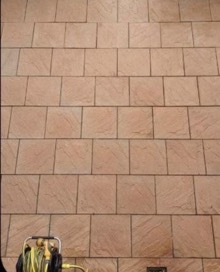 The same sandstone paving after cleaning, warm pink stone