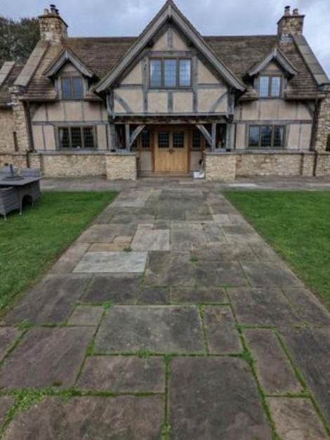 A sandstone path and frontage before cleaning, greyed over with algae