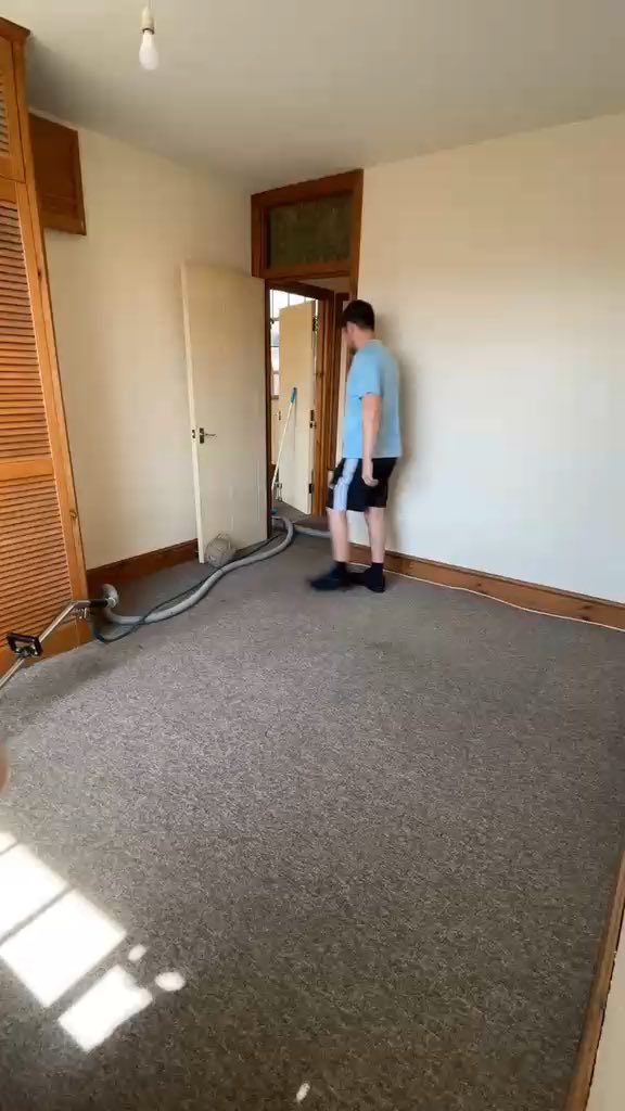 A carpet being cleaned in an empty room