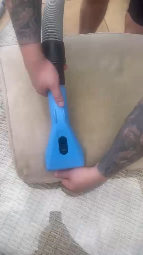 An upholstery tool being drawn across a sofa cushion